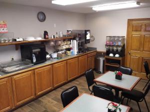 a kitchen with wooden cabinets and tables and chairs at Americas Best Value Inn York in York