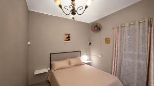 a bedroom with a bed and a chandelier at Casa LeValois - Hidden Garden Oasis in Port-Louis in Port Louis