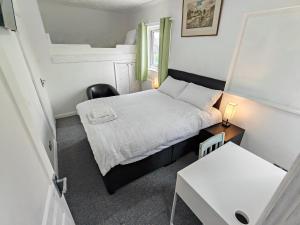 a small bedroom with a bed and a table at Cherry Studio - Self Contained One-Bed Studio Flat in Oxford