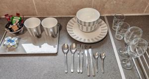 a table with forks and spoons and wine glasses at Cherry Studio - Self Contained One-Bed Studio Flat in Oxford +9 photos