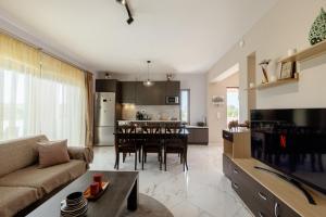 a living room and kitchen with a table and a couch at Valentina's Luxe Apartment in Mastihari