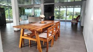 a wooden table with chairs and a vase of flowers on it at Finca Santa Rita in Pereira
