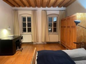 a bedroom with a bed and a desk and windows at Historisches Bürgerhaus Hartlschuster in Neufelden +10 photos