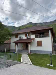 a white house with mountains in the background at Skyline Villa Boge in Bogë +10 photos