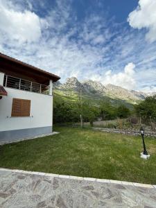 a house with a yard with mountains in the background at Skyline Villa Boge in Bogë