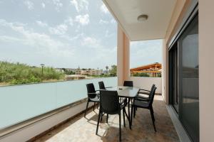 a balcony with a table and chairs and a large window at Valentina's Luxe Apartment in Mastihari
