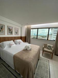 a bedroom with a large white bed and a chair at AliReserva Luxury Suites in Palmas +203 photos