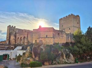 a castle on a hill with the sun setting behind it at La Loggia, Historic Center in Grottaglie