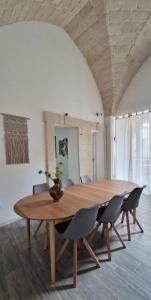 a wooden table and chairs in a room at La Loggia, Historic Center in Grottaglie +19 photos