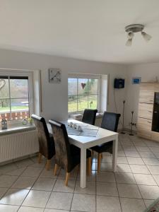 a dining room with a white table and chairs at Ferienwohnung Tina in Nettersheim +8 photos