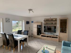 a living room with a table and chairs and a television at Ferienwohnung Tina in Nettersheim