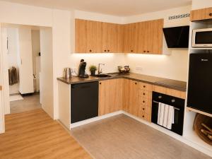 a kitchen with wooden cabinets and black appliances at Haus Erna Weitra in Weitra +5 photos