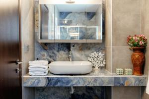 a bathroom with a sink and a vase with flowers at Valentina's Luxe Apartment in Mastihari +58 photos
