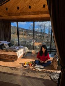 a woman sitting on the floor in a room with a bed at View Apartament Kasprowy Wierch Premium DeLuxe & SPA in Kościelisko