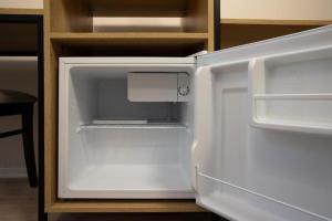 an empty refrigerator with its door open in a kitchen at Hotel Mozart in Durrës
