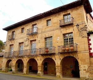 a large brick building with balconies on a street at Casa Rural Palacio Armiñón in Armiñón