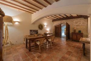 a dining room with a table and a stone wall at Casa Rural Palacio Armiñón in Armiñón