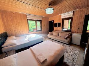 a room with two beds and a couch in it at Yüce Suite in Uzungöl