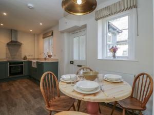 a kitchen with a wooden table with chairs and a window at Middle Cottage in Salisbury