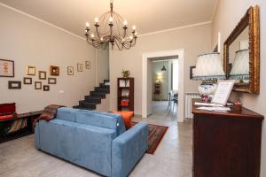 a living room with a blue couch and a chandelier at Appartamento Ferdinando - Relax & Style in Caserta