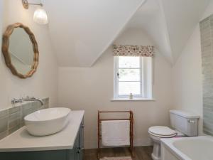 a bathroom with a sink and a toilet and a window at Middle Cottage in Salisbury