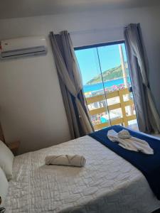 a bedroom with a bed with a view of the ocean at Pousada Thetis in Arraial do Cabo +58 photos