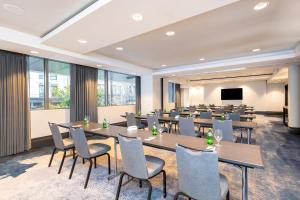 a conference room with tables and chairs and a screen at Hotel 1000, In The Unbound Collection By Hyatt in Seattle