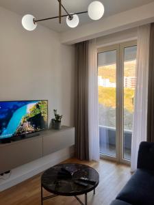 a living room with a tv and a table at Mare Sea View Suites ,One Bedroom 305 in Bečići