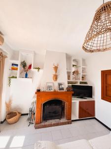 a living room with a fireplace and a chandelier at Casa Almonte in Almonte