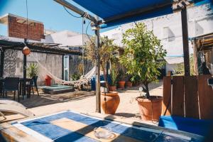 a patio with a hammock and potted plants at Casa Caracol in Cádiz