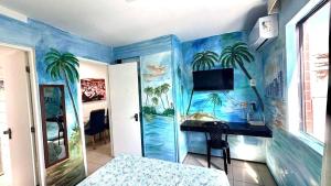 a bedroom with a mural of palm trees on the wall at Praia Mansa Suite Hotel Flat in Fortaleza