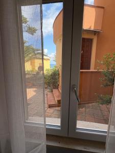 a sliding glass door with a view of a courtyard at Appartamenti Flora in Castelsardo