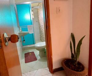 a bathroom with a toilet and a sink and a potted plant at Hostal Casa Lantana in Suesca