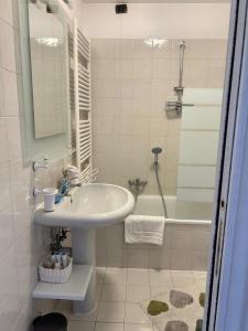 a white bathroom with a sink and a tub at Il re di Torino in Turin