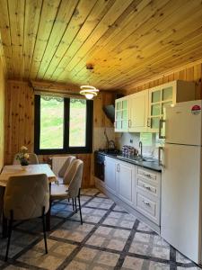 a kitchen with a table and a white refrigerator at Yüce Suite in Uzungöl