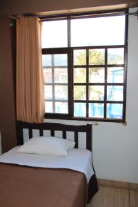 a bed in a room with a large window at hotel turistico in Huaraz +1 photo