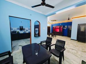 a room with two chairs and a table and a ceiling fan at Royal Villa Pondy in Pondicherry