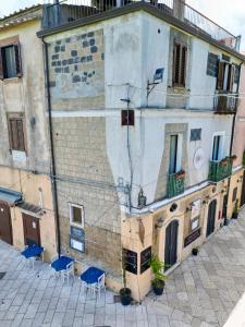 an old building with blue chairs in front of it at B&B Sunset Suite Belvedere in Sant'Agata de' Goti