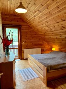 a bedroom with a bed in a wooden room at DOM w BORACH in Cekcyn