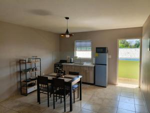 a kitchen with a table and chairs and a refrigerator at Passion Care in Willemstad