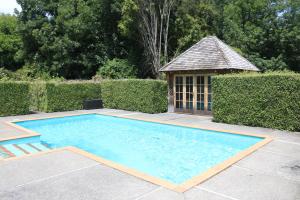 a swimming pool with a gazebo in a yard at Akaroa Country House in Akaroa