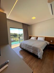 a bedroom with a large bed and a large window at Cascata Boutique Hotel in Várzea da Palma