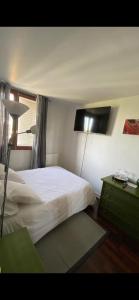 a bedroom with a bed and a lamp and a table at chambre Cosy et Chambre Sam in Rosny-sous-Bois