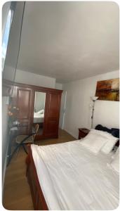 a bedroom with a white bed and a mirror at chambre Cosy et Chambre Sam in Rosny-sous-Bois