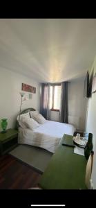 a bedroom with a white bed and a desk and a window at chambre Cosy et Chambre Sam in Rosny-sous-Bois