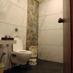 a bathroom with a white toilet in a room at Hotel Abhilash in Pachmarhī