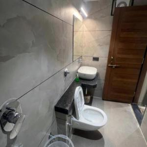 a bathroom with a toilet and a sink at Hotel Abhilash in Pachmarhī