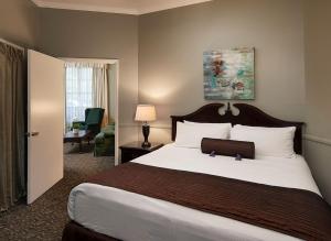 a hotel room with a large bed with a suitcase on it at Lavender Inn by the Sea in Santa Barbara +23 photos