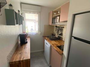a small kitchen with a sink and a refrigerator at MAISON les ARCADES in Soustons +11 photos