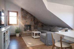a living room with a couch and a fireplace at Ibón de tebarray in Escarrilla